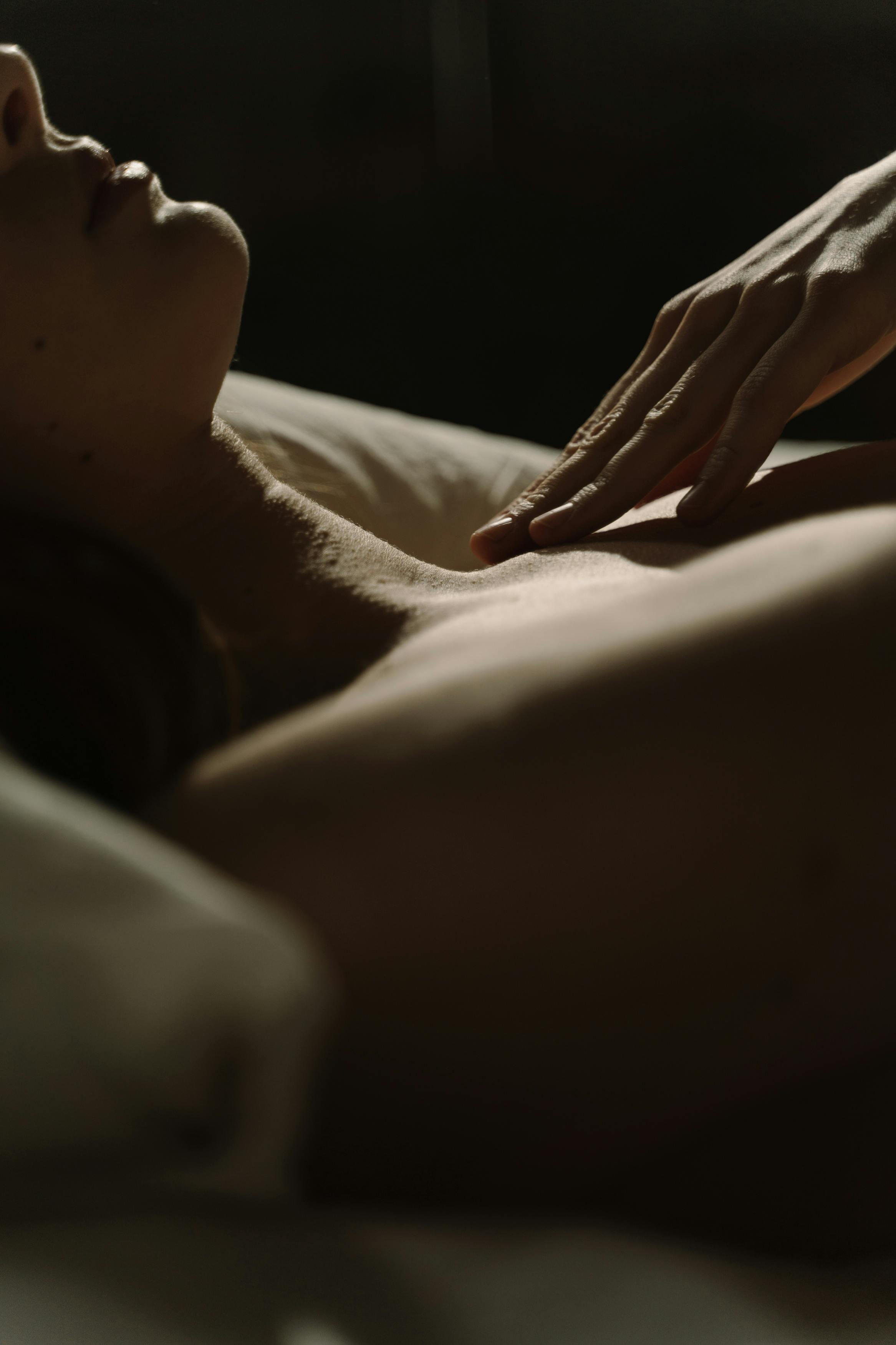 Women with smooth decollatage laying in bed with her hand on her chest.
